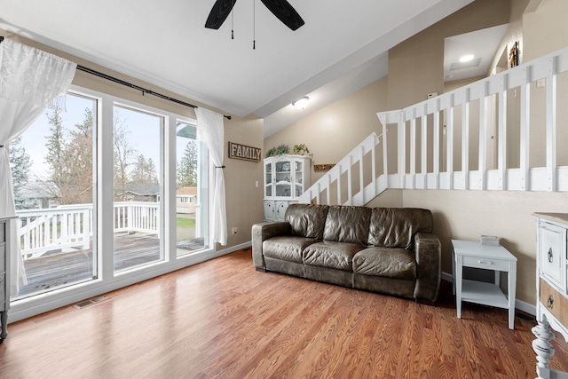 living room with ceiling fan, wood-type flooring, and vaulted ceiling