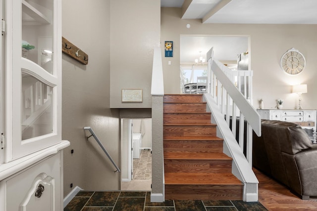 staircase featuring an inviting chandelier