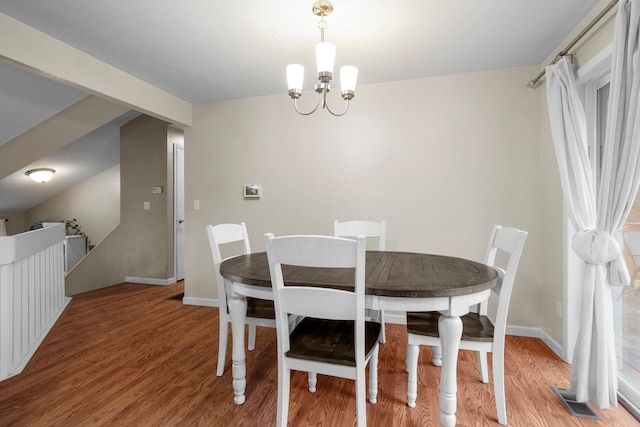 dining area featuring hardwood / wood-style floors and a notable chandelier