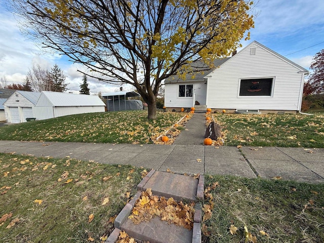 view of front of house featuring an outbuilding, a garage, and a front yard