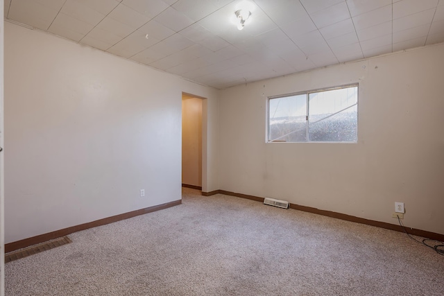 carpeted empty room featuring visible vents and baseboards