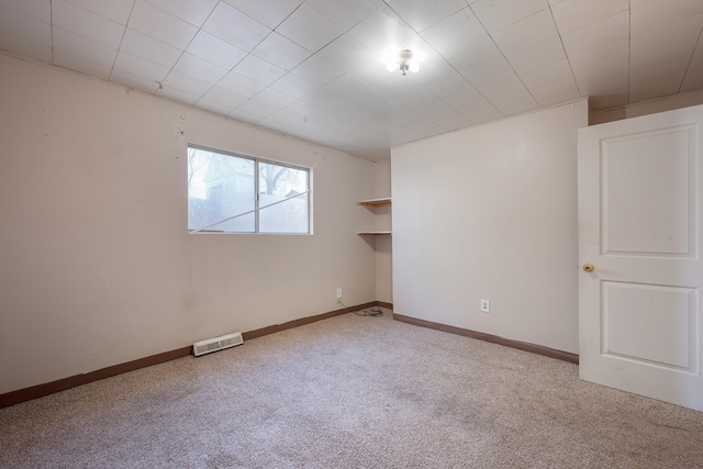 carpeted spare room featuring visible vents and baseboards