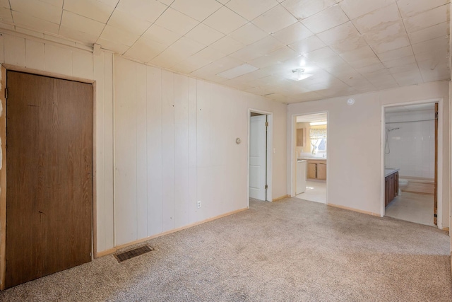 carpeted spare room with baseboards and visible vents