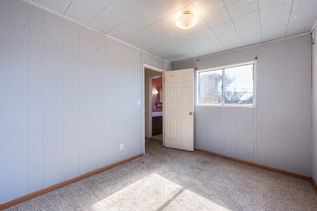 carpeted spare room with baseboards