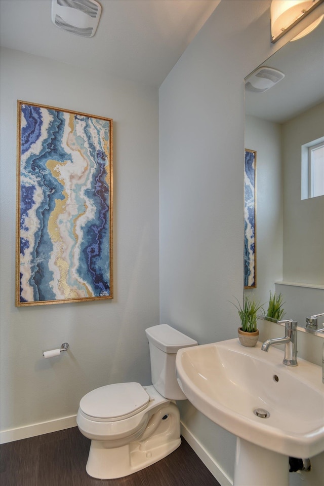 bathroom featuring wood-type flooring, toilet, and sink