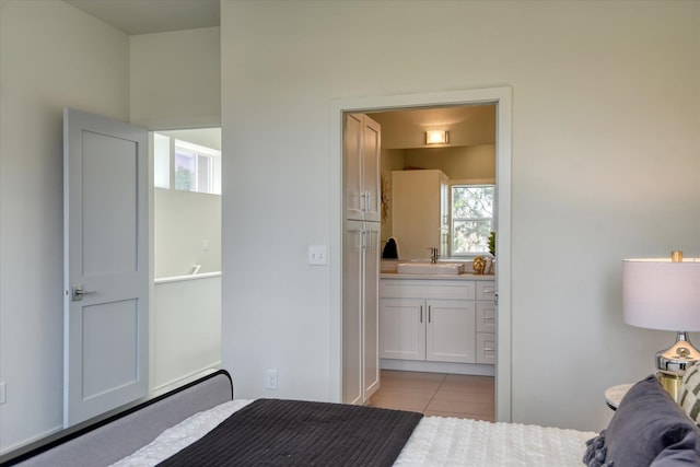 tiled bedroom featuring sink and ensuite bath