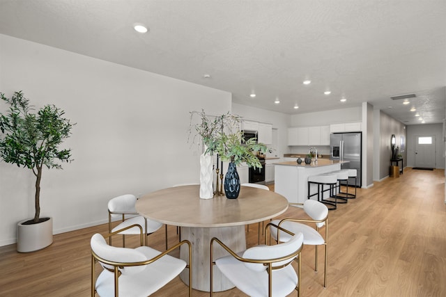 dining space with recessed lighting, visible vents, and light wood-style flooring