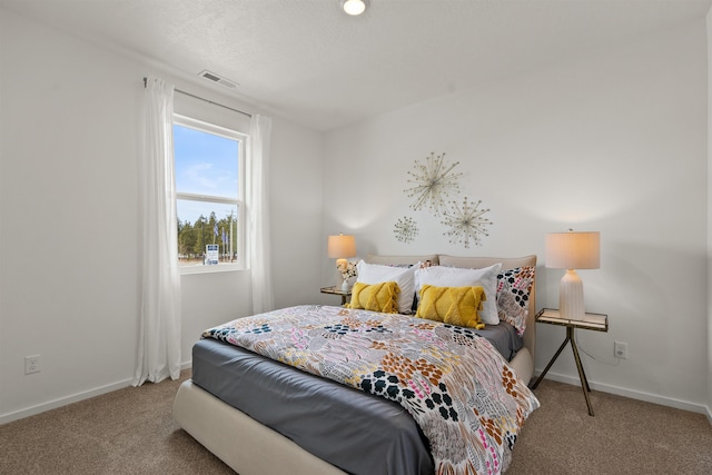 bedroom featuring carpet floors, visible vents, and baseboards