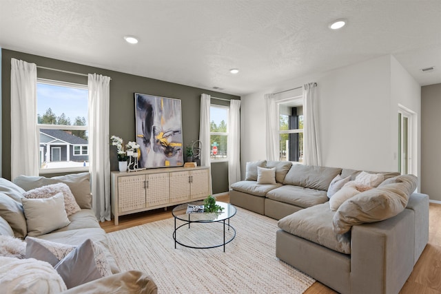 living area with a wealth of natural light, recessed lighting, and wood finished floors