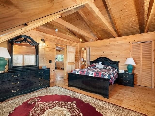 bedroom featuring wood ceiling, wooden walls, lofted ceiling with beams, and hardwood / wood-style flooring