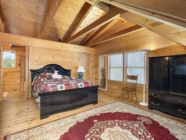 bedroom featuring vaulted ceiling with beams, wood-type flooring, wooden walls, and wooden ceiling