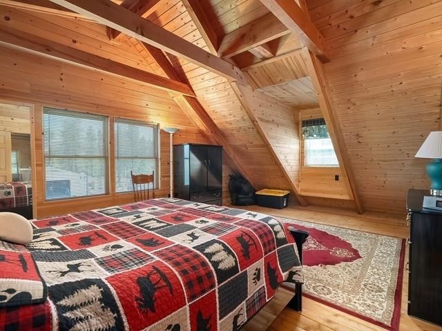 bedroom with hardwood / wood-style floors, lofted ceiling with beams, wood walls, and wooden ceiling