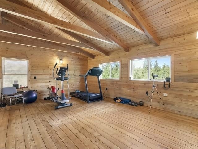 workout room with wooden walls, wood ceiling, vaulted ceiling, and hardwood / wood-style flooring