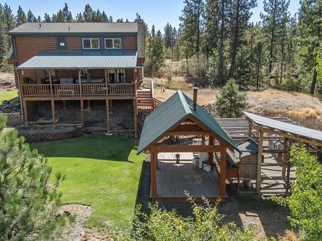 rear view of house featuring a gazebo, a yard, and a deck