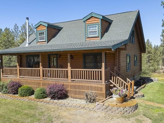 log cabin featuring covered porch and a front yard