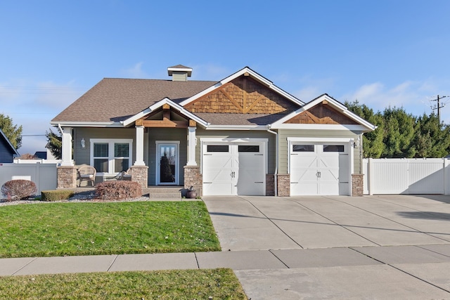 craftsman house featuring a front yard and a garage