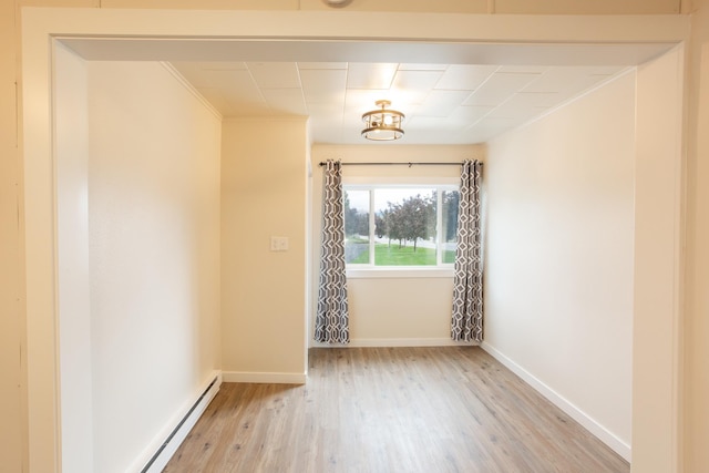 unfurnished room with light hardwood / wood-style floors, a baseboard radiator, and ornamental molding