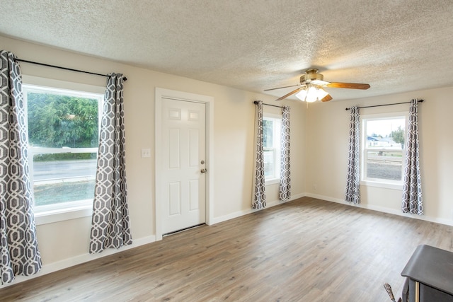 foyer with ceiling fan, wood-type flooring, and a textured ceiling