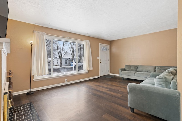 living room featuring a textured ceiling, dark hardwood / wood-style flooring, and a tiled fireplace