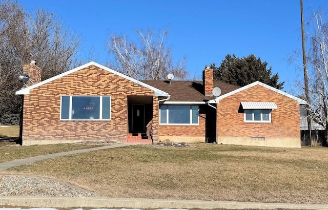 ranch-style house featuring a front yard, brick siding, roof with shingles, and a chimney