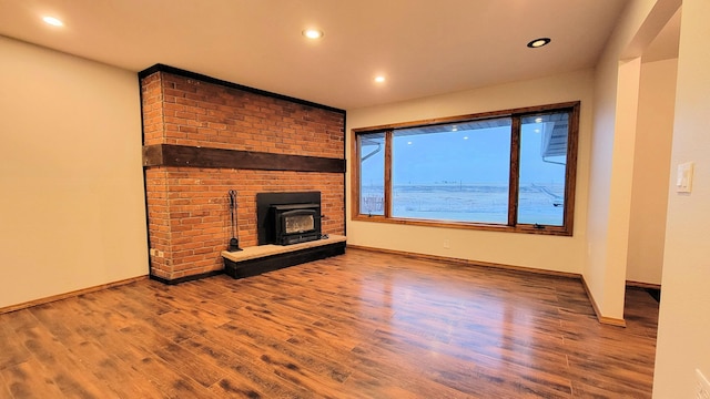 unfurnished living room featuring recessed lighting, wood finished floors, and baseboards