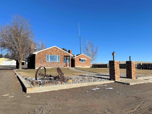 ranch-style home featuring fence and brick siding