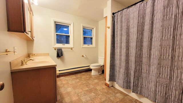 full bath with curtained shower, double vanity, a sink, a baseboard heating unit, and toilet