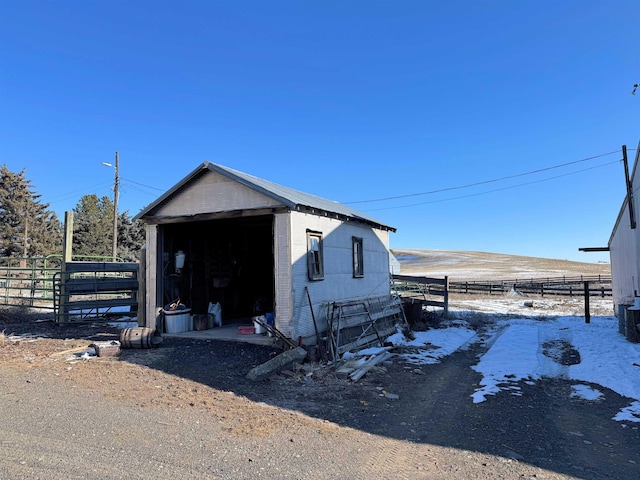 view of outbuilding featuring an outbuilding, central AC unit, and fence