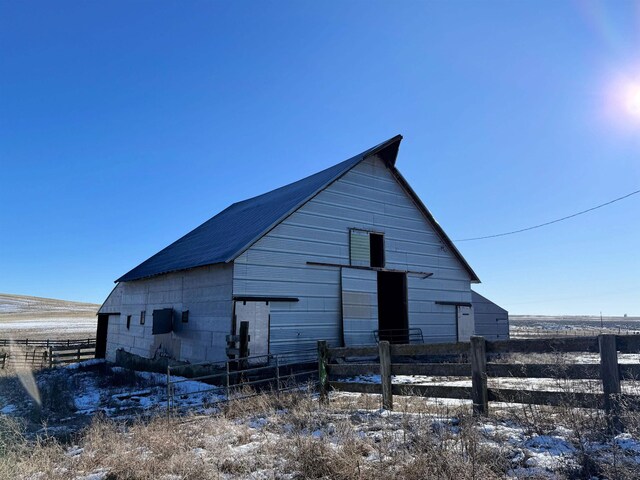 exterior space featuring a barn, fence, and an outbuilding