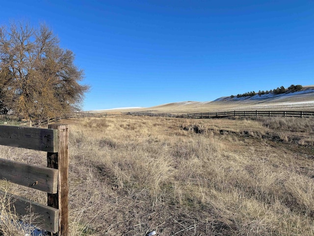 view of yard with a rural view and fence