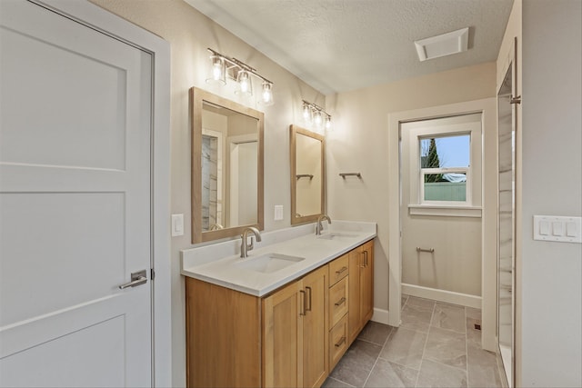 16924 E 16th Ln, Spokane Valley, WA 99037 - bathroom featuring double vanity, baseboards, and a textured ceiling