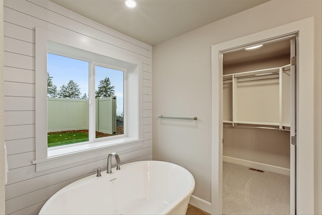 bathroom with wooden walls and a bathing tub