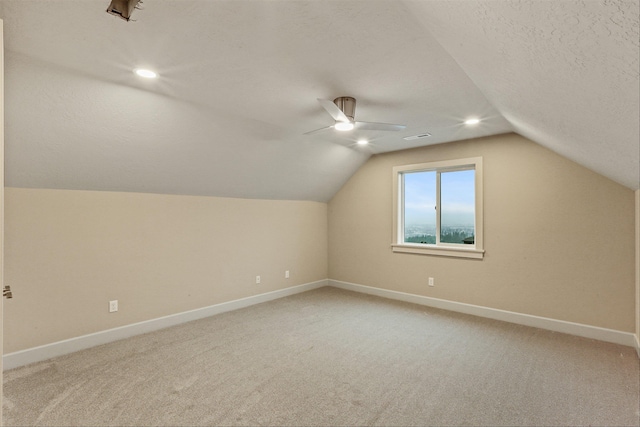 additional living space featuring a textured ceiling, ceiling fan, carpet, and vaulted ceiling