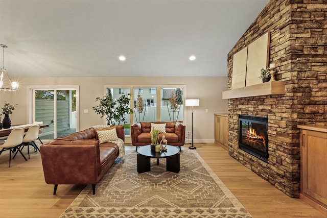 living room with a fireplace, vaulted ceiling, and light wood-type flooring