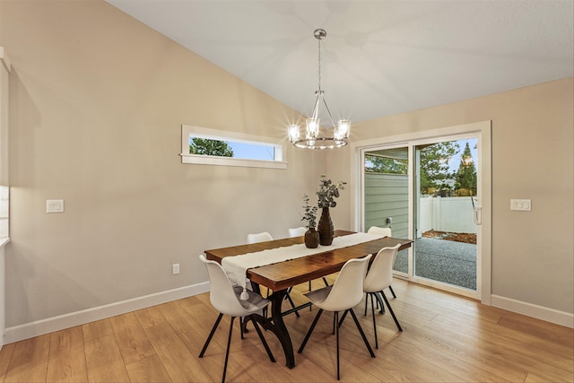 dining room featuring a chandelier, light hardwood / wood-style floors, vaulted ceiling, and plenty of natural light