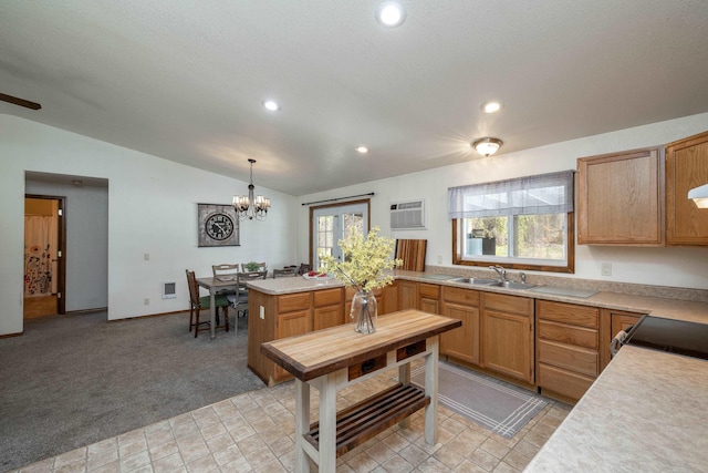 kitchen with pendant lighting, light colored carpet, vaulted ceiling, and a wealth of natural light