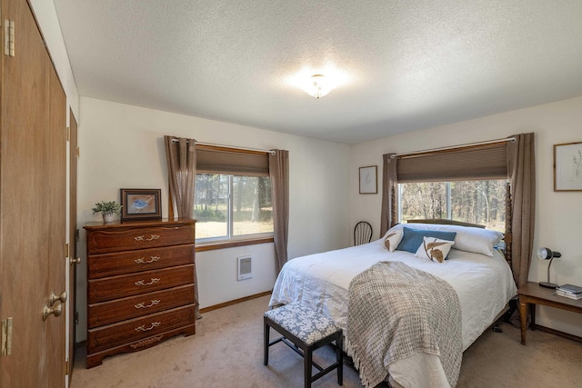 bedroom featuring a textured ceiling and light carpet