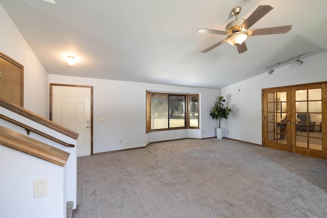 unfurnished living room with ceiling fan, french doors, light colored carpet, and vaulted ceiling