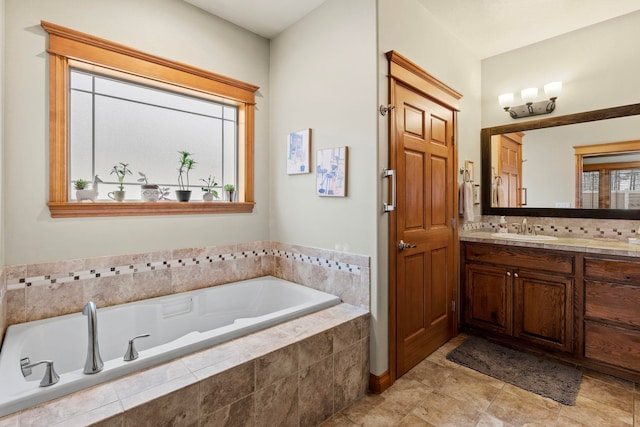 bathroom with tiled tub and vanity