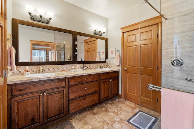 bathroom with vanity, decorative backsplash, and a shower with door