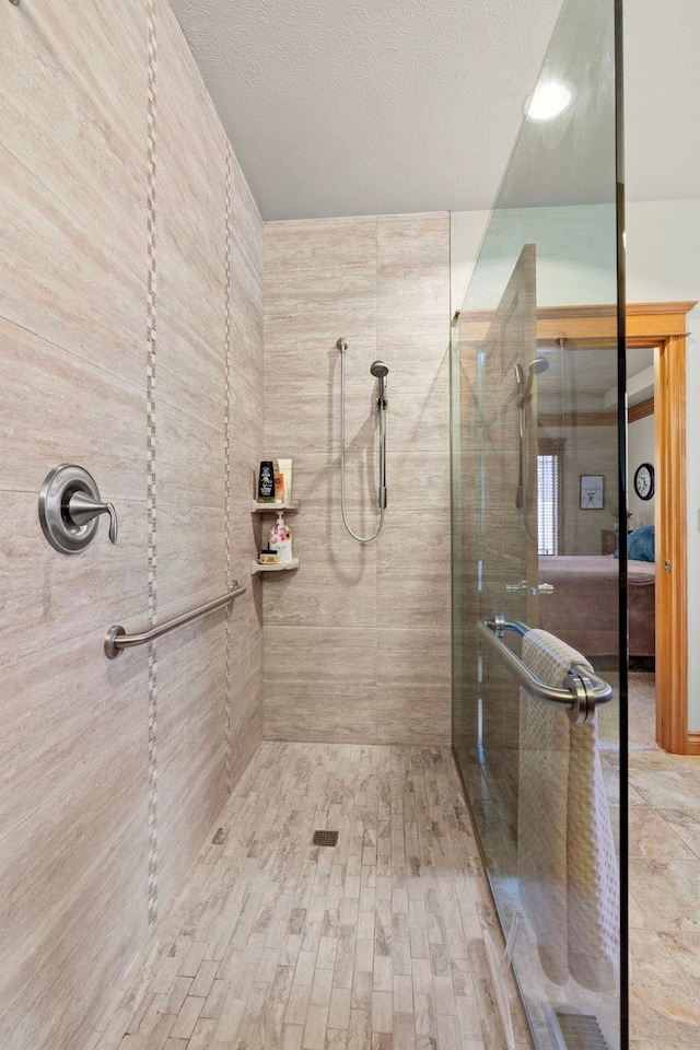 bathroom featuring a textured ceiling and a tile shower