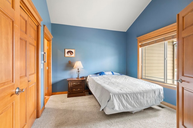 bedroom featuring carpet, a closet, and vaulted ceiling