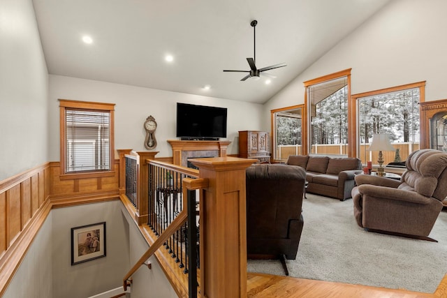 living room with ceiling fan, lofted ceiling, a fireplace, and light hardwood / wood-style floors