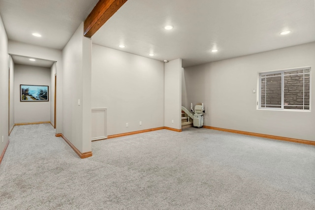 carpeted spare room with beamed ceiling