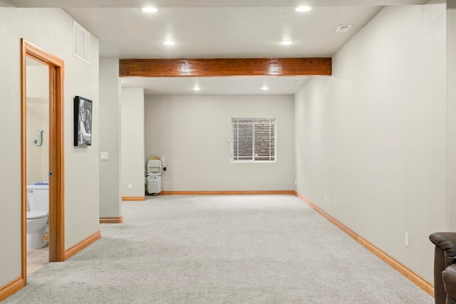 carpeted spare room featuring beam ceiling