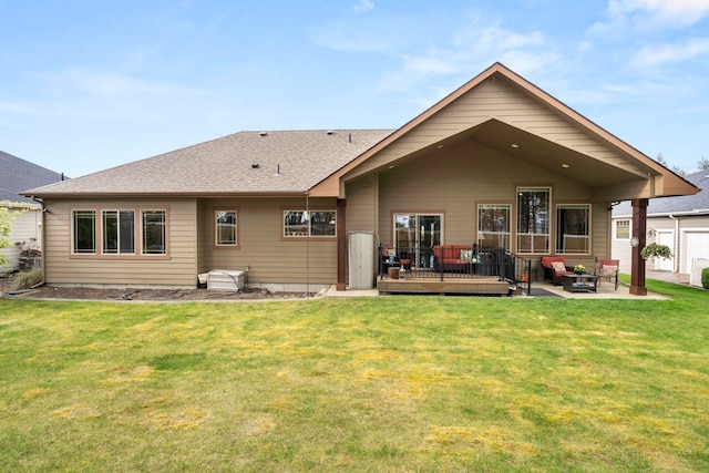 rear view of property featuring a wooden deck, a patio area, and a lawn