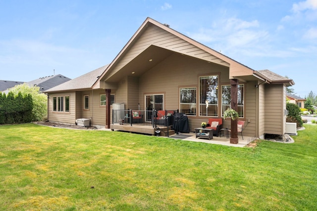 back of house with a lawn, a patio, and a wooden deck