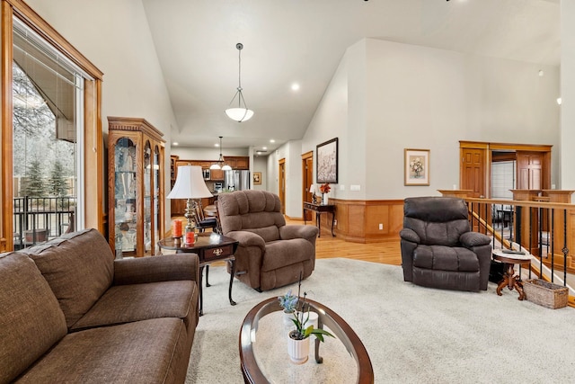 living room with light colored carpet and high vaulted ceiling