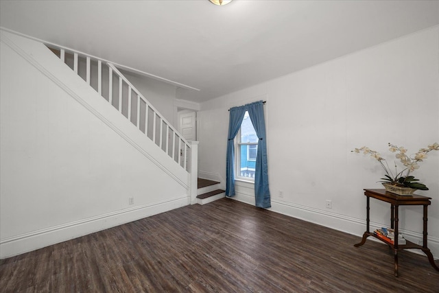 unfurnished living room with dark wood-type flooring