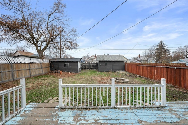 wooden terrace with a lawn and a storage unit